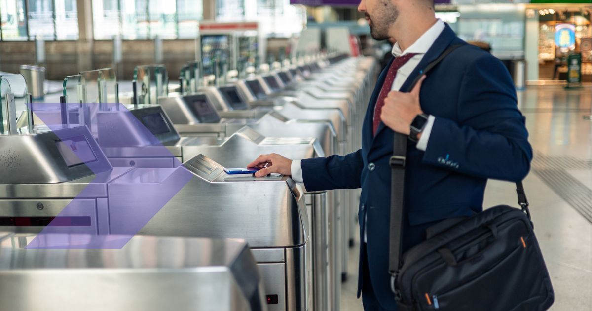 Business man dressed in suit using his phone to register his ticket on a public transport checkpoint