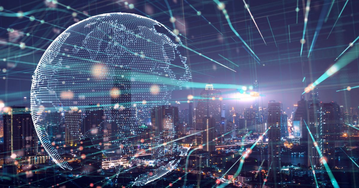 Cityscape by night with light up globe and lines illustrating IoT connecitivity