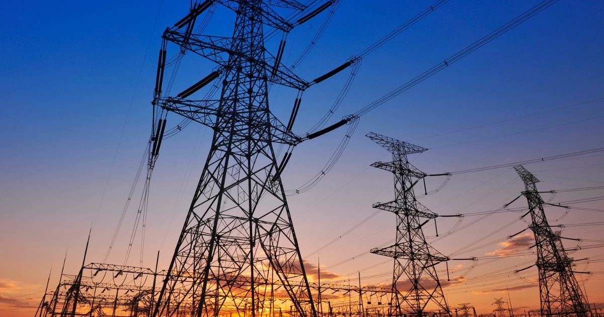 Sunset sky with colours from orange to blue with large power masts in the front